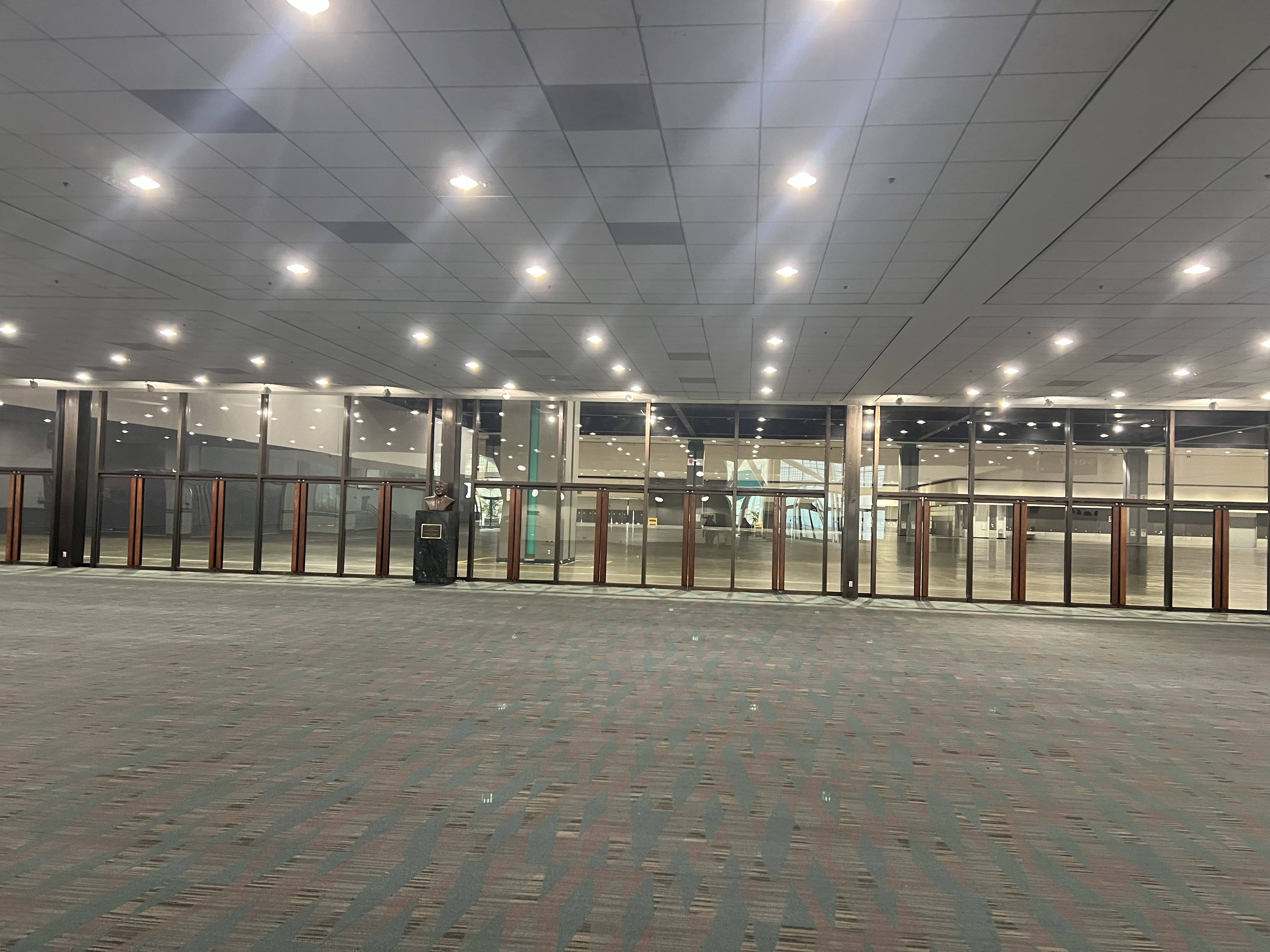 [alt-text: a photo of the entrance to the Bookfair, comprised of multiple sets of glass doors]