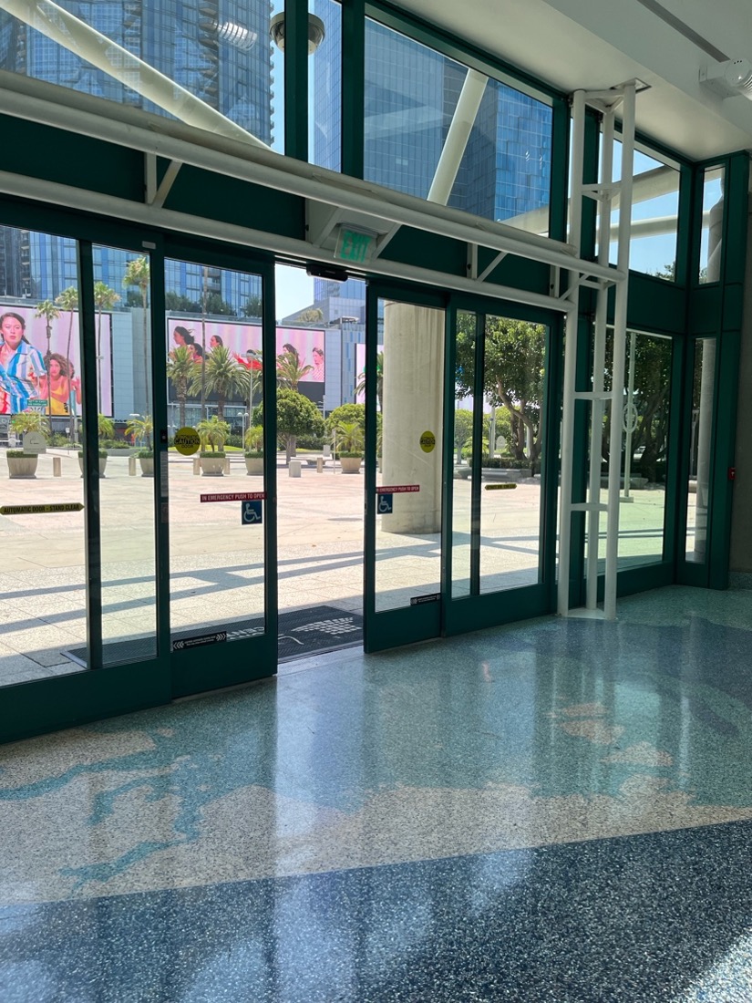 [alt text: Black framed automatic glass sliding doors into the west entrance of the Los Angeles Convention Center.]