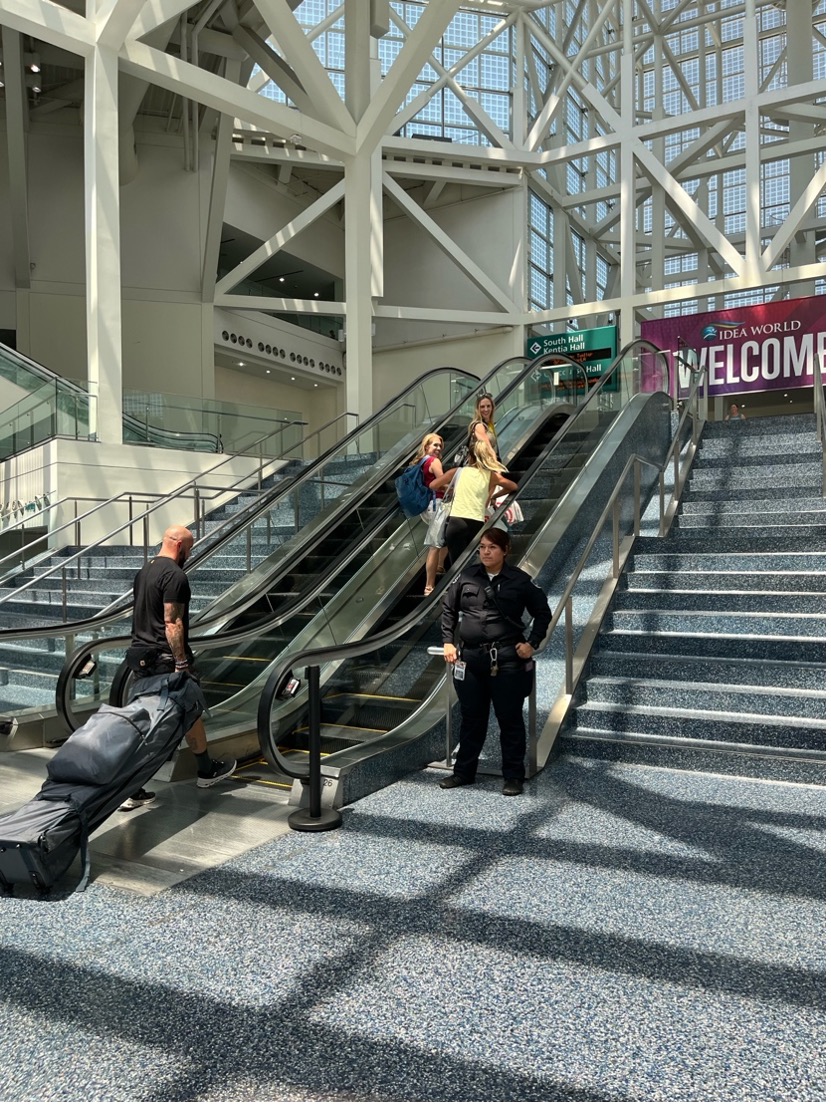 [alt text: a photo of a pair of escalators in between sets of stairs leading to the West Lobby of the Los Angeles Convention Center]