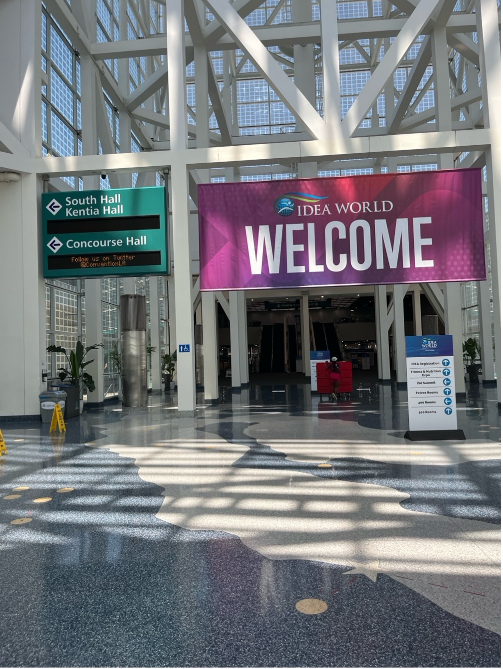 The landing space, with high ceilings and full of natural light, which opens up to hallways in the Los Angeles Convention Center.