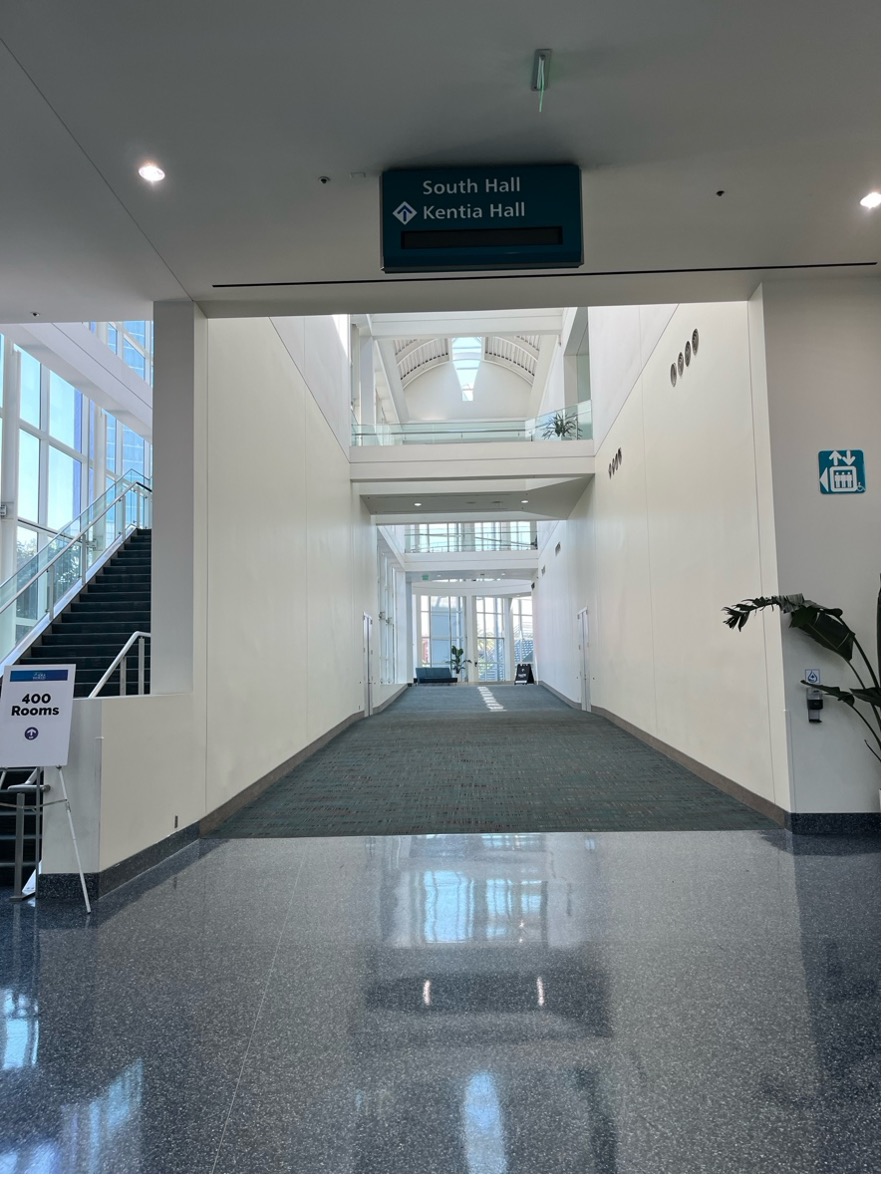 Looking down a hallway. Wall signage indicates proximity to an elevator.